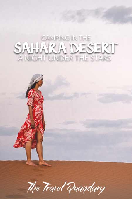 A Night Under The Stars Camping In The Sahara Desert2 A woman in a red dress stands on a sand dune under the early moon at dusk, Sahara Desert Morocco