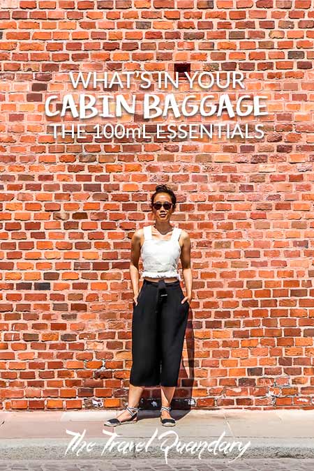Whats In Your Cabin Baggage the 100mL Essentials2 Jasmine of The Travel Quandary poses in front of a red brick wall in Krakow, Poland | Cabin Baggage Liquids Allowance