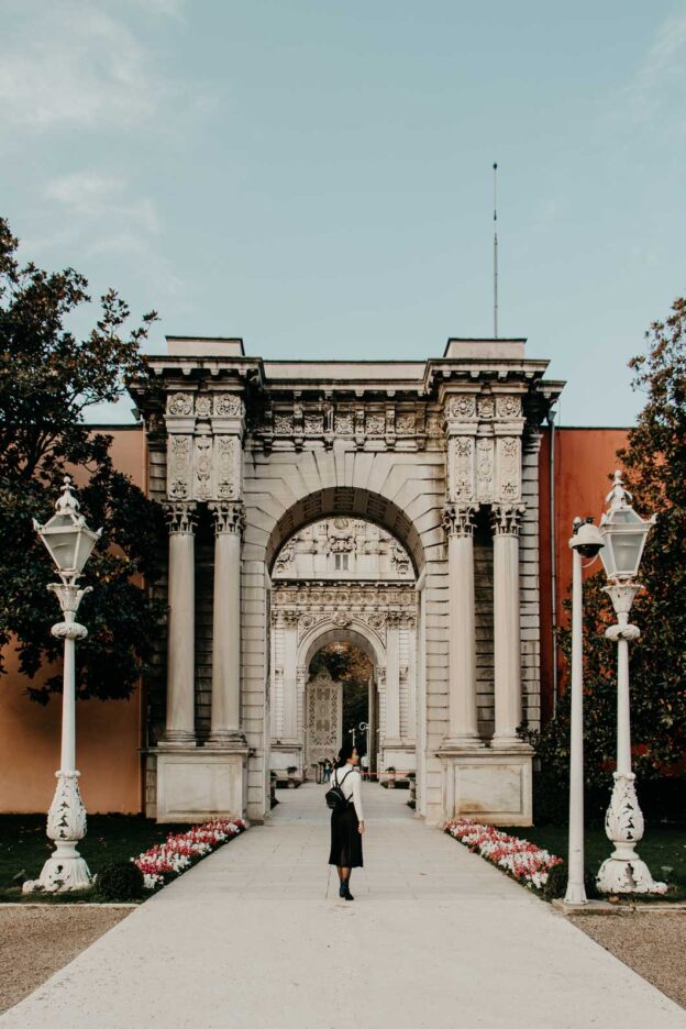 Walking around the grounds and under a maginificent archway of Dolmabahçe Palace, Istanbul, Türkiye