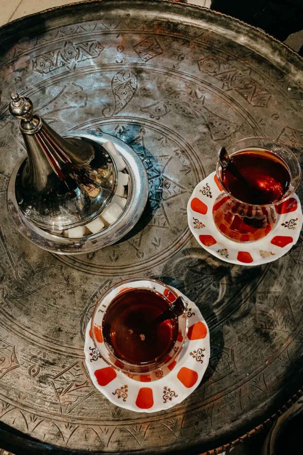 Two cups of tradtional Turkish tea and plate of sugar cubes in Türkiye