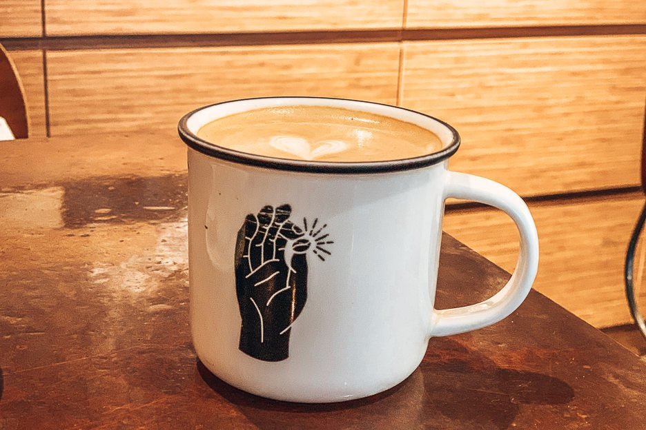 A large latte in a tin mug at Urban Coffee Roaster, Hong Kong
