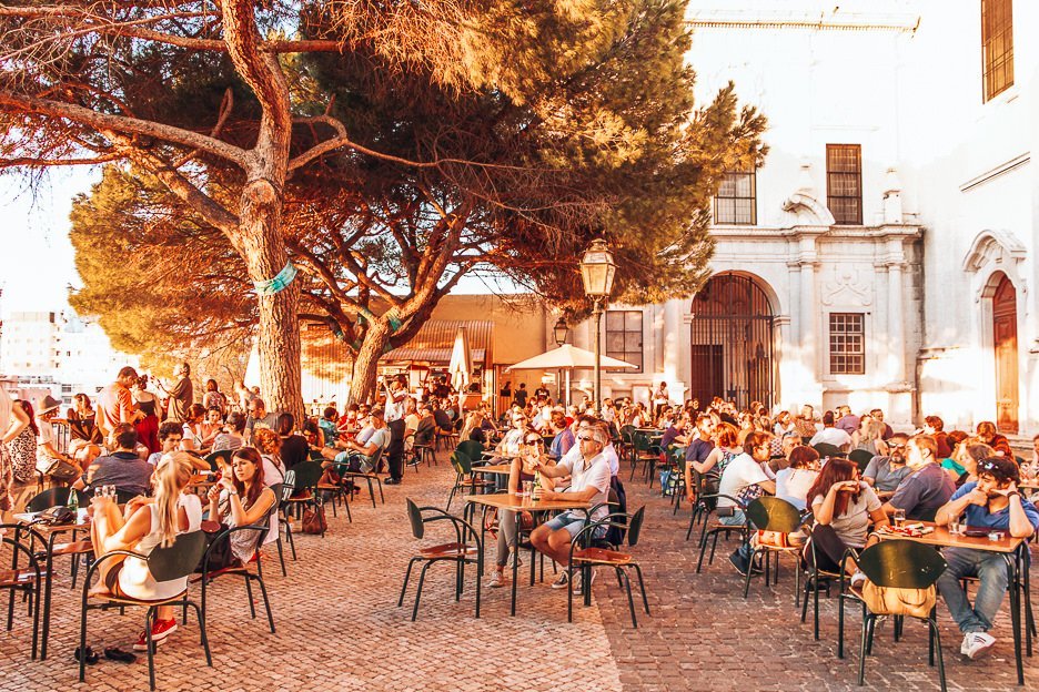 Crowds sit in the afternoon sun at Terrace Bar Esplanada, Lisbon