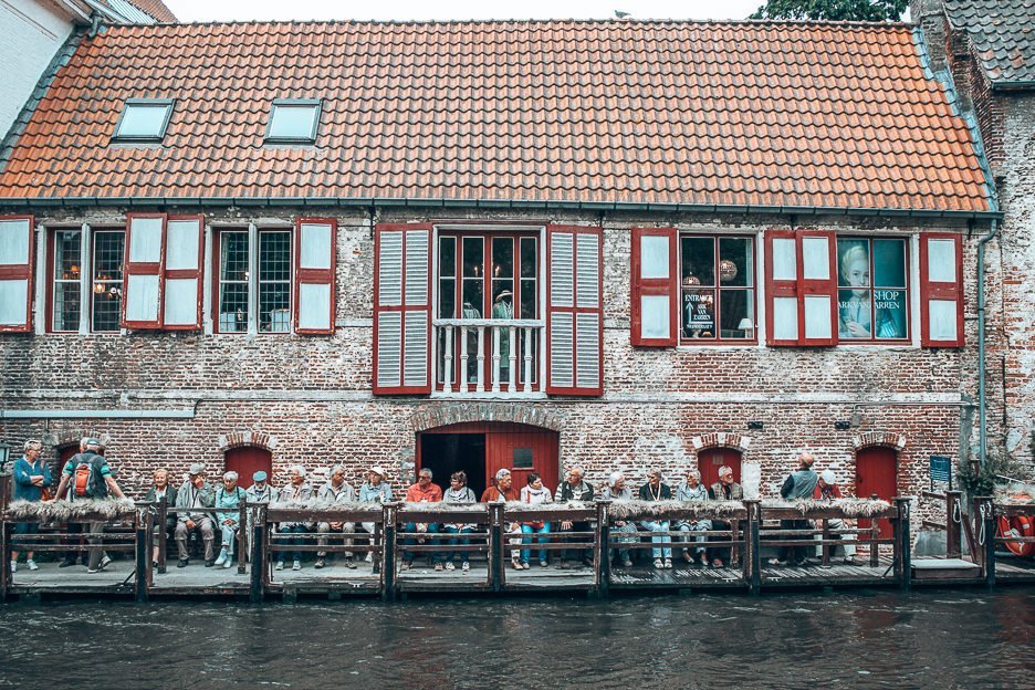 A Complete Guide To 24 Hours In Bruges 8 L A group of tourists wait for the canal boat ride in Bruges Belgium
