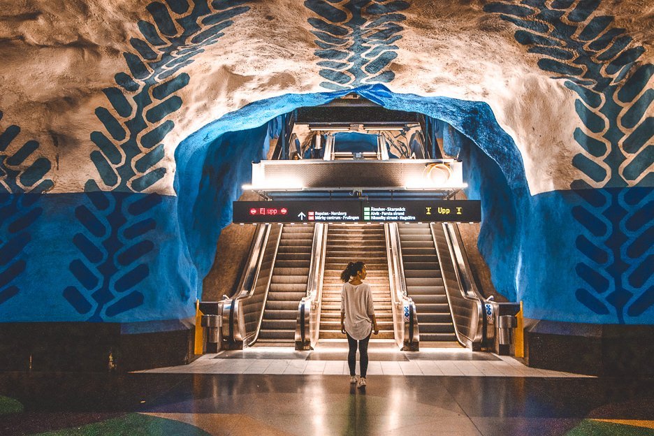 Jasmine stands under the blue leaf arch on the blue metro line at Central Station - Stockholm, Sweden