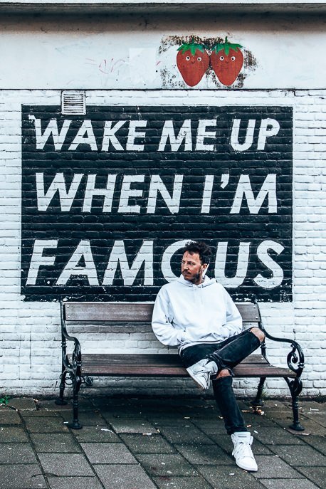 A Non Touristy Weekend Guide To Amsterdam 17 P Sitting in front of the Wake Me Up When I'm Famous sign, Amsterdam