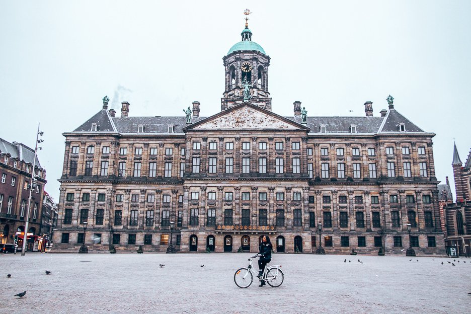 Posing in front of the Royal Palace on a bicycle in Dam Square, Amsterdam