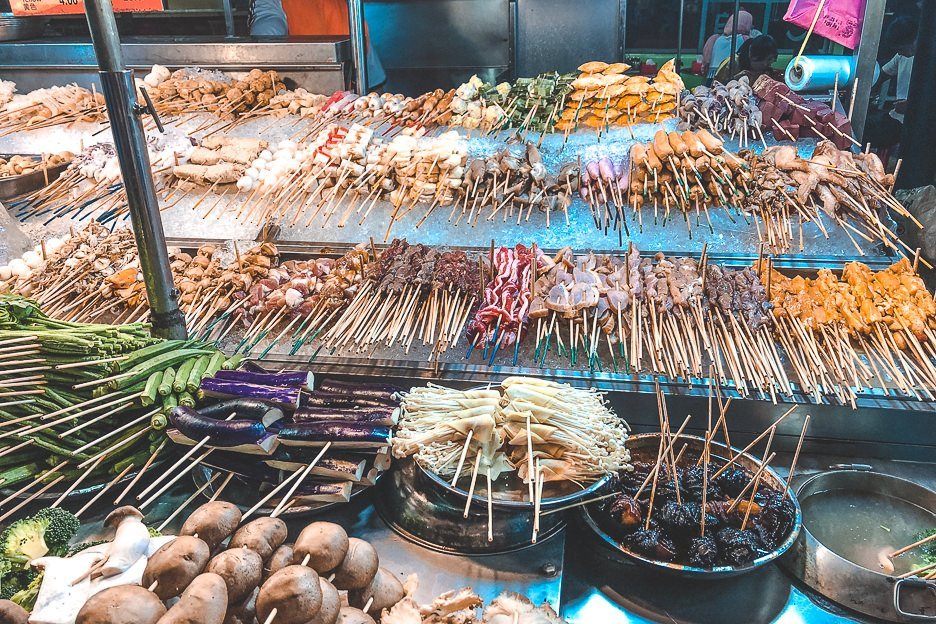 Satay sticks with meat and vegetables are lined up at a food stall, Kuala Lumpur