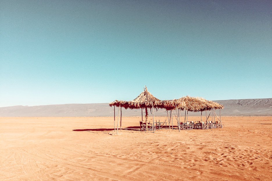 Chairs and palm tree shade covers in the Sahara Desert, Morocco