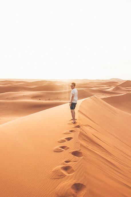 Camping Under The Stars A Night In The Sahara Desert 8 P A man leaves footprints along a dune in the Sahara Desert, Morocco