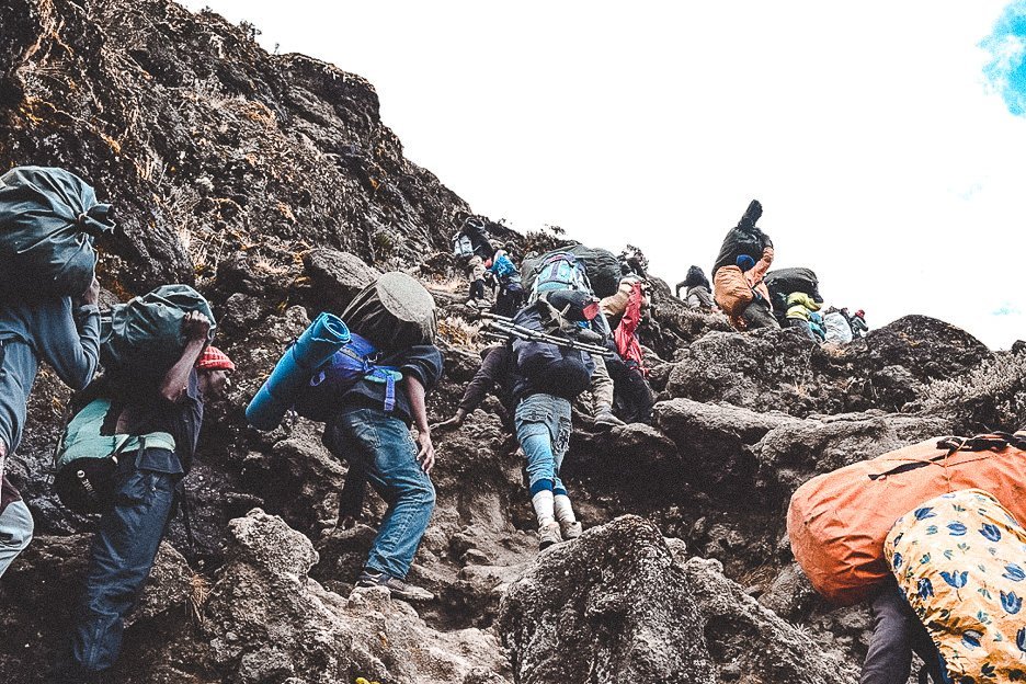 Porters carrying their loads up the Barranco Wall on Mt Kilimanjaro