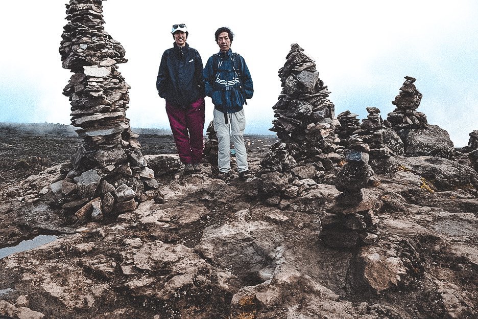 Jasmine and her dad standing among rock formations close to Shira Camp on the Machame Route over 7 days
