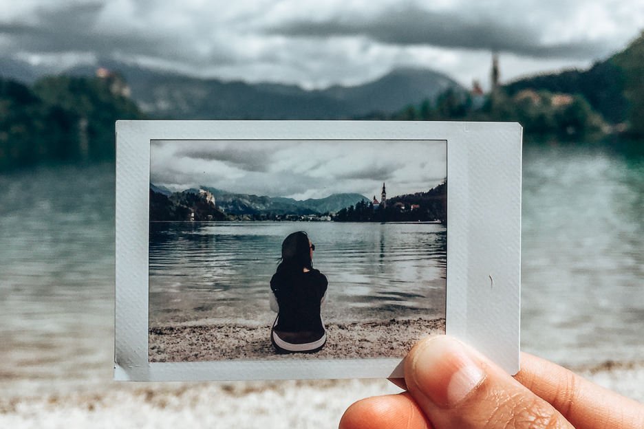 Polaroid snap of Jasmine sitting on the shore of Lake Bled, Slovenia