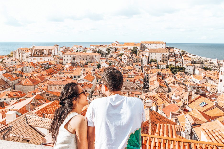A couple look out over the red roofs of Dubrovnik's Old Town from the city walls, Dubrovnik