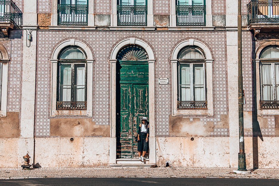 Jasmine posing in a green doorway next to pink Portuguese tiles, Lisbon