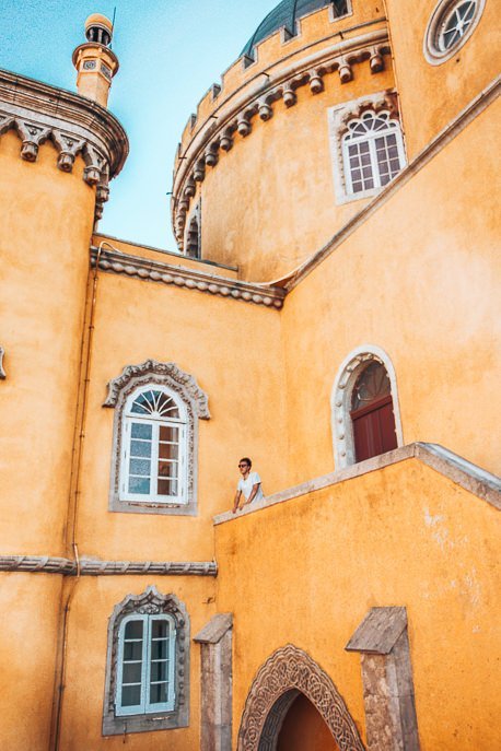 How To Spend The Perfect 3 Days In Lisbon 3 P Bevan stands on a balcony amidst the yellow castle walls of Pena Palace, Sintra - Lisbon