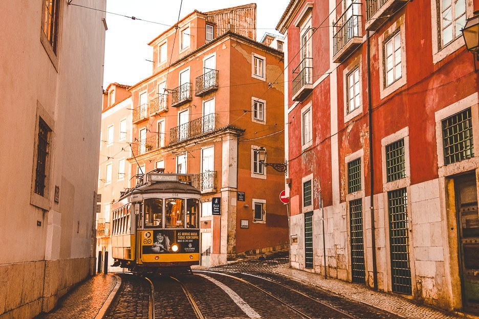 The famous yellow tram 28 trundles down a hill in Lisbon