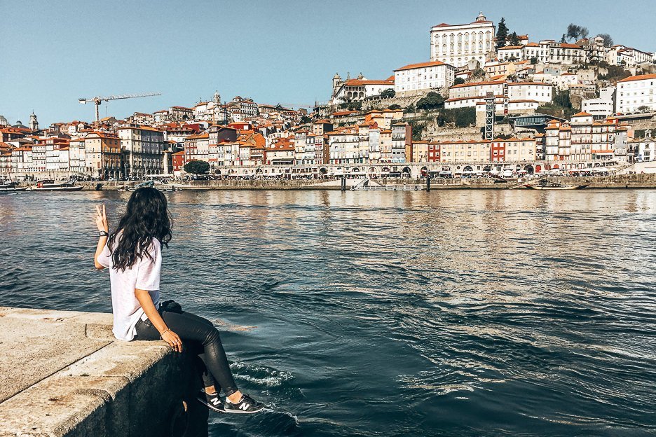 Jasmine sits at the harbourfront across for Porto city, Portugal