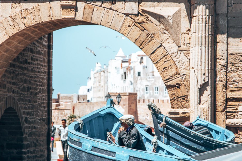 Morocco Travel Photography 35 Photos To Inspire You To Visit 21 L An old Moroccan man sits inside a blue boat ready to pose for photos for tourists at Essaouira harbour, Morocco