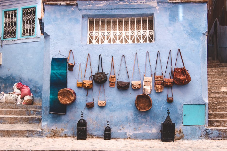 Leather bags hand on a wall for sale in the blue city of Chefchaouen, Morocco