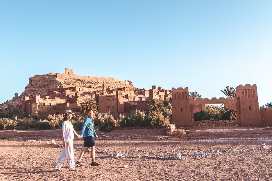 Morocco Travel Photography 35 Photos To Inspire You To Visit 4 L A couple walk hand in hand in front of the ancient kasbah of Ait Benhaddou, Morocco