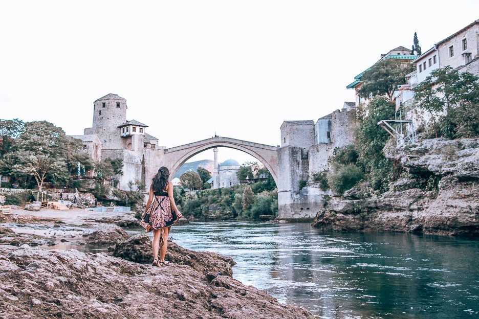Jasmine walking by the banks of the Neretza River in front of the Stari Most in Mostar, Bosnia & Herzegovina