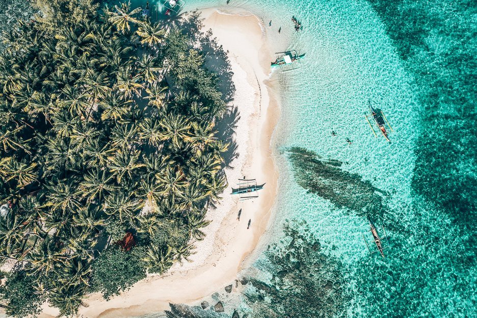 Siargao Itinerary And Guyam Island from above. Palm trees, beach and water