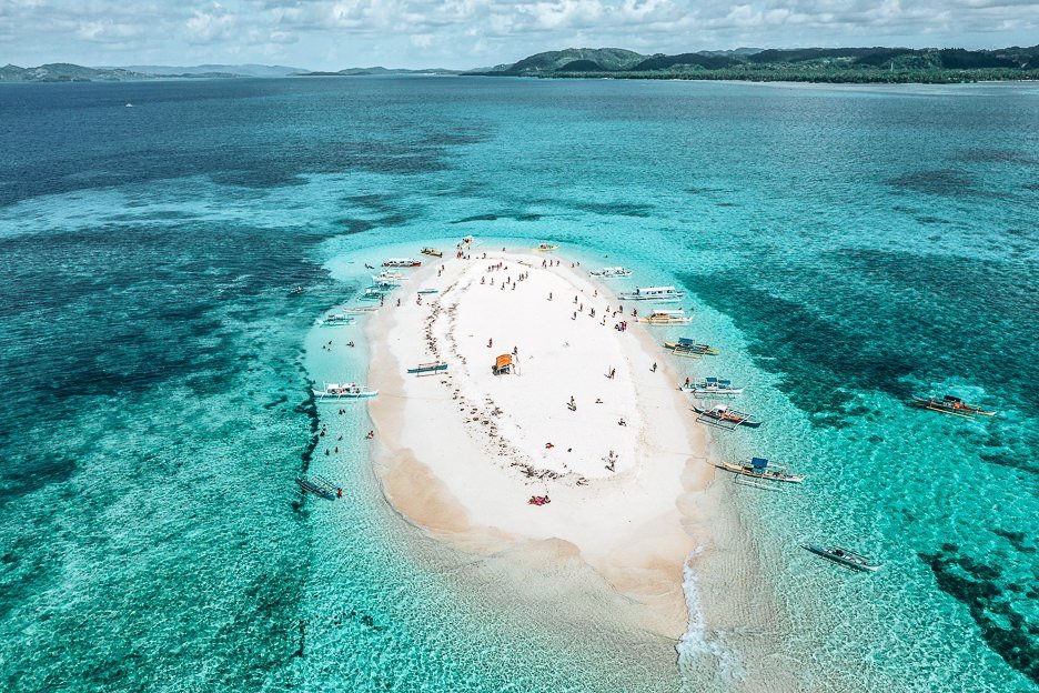 Aerial view of poeple and boats on Naked Island, Siargao