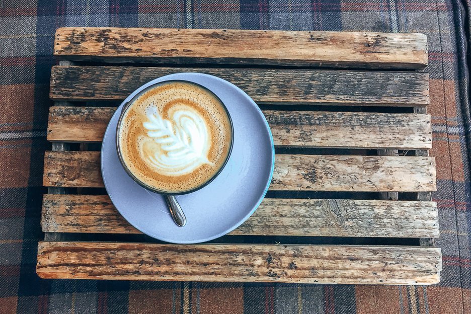 A latte served on a wooden tray at The Milkman, Coffee in Edinburgh Scotland