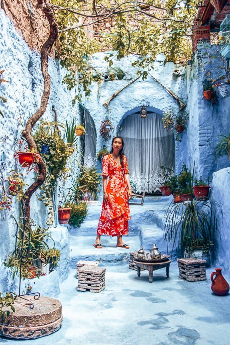 Jasmine of The Travel Quandary posts in a traditional Moroccan courtyard in Chefchaouen Morocco