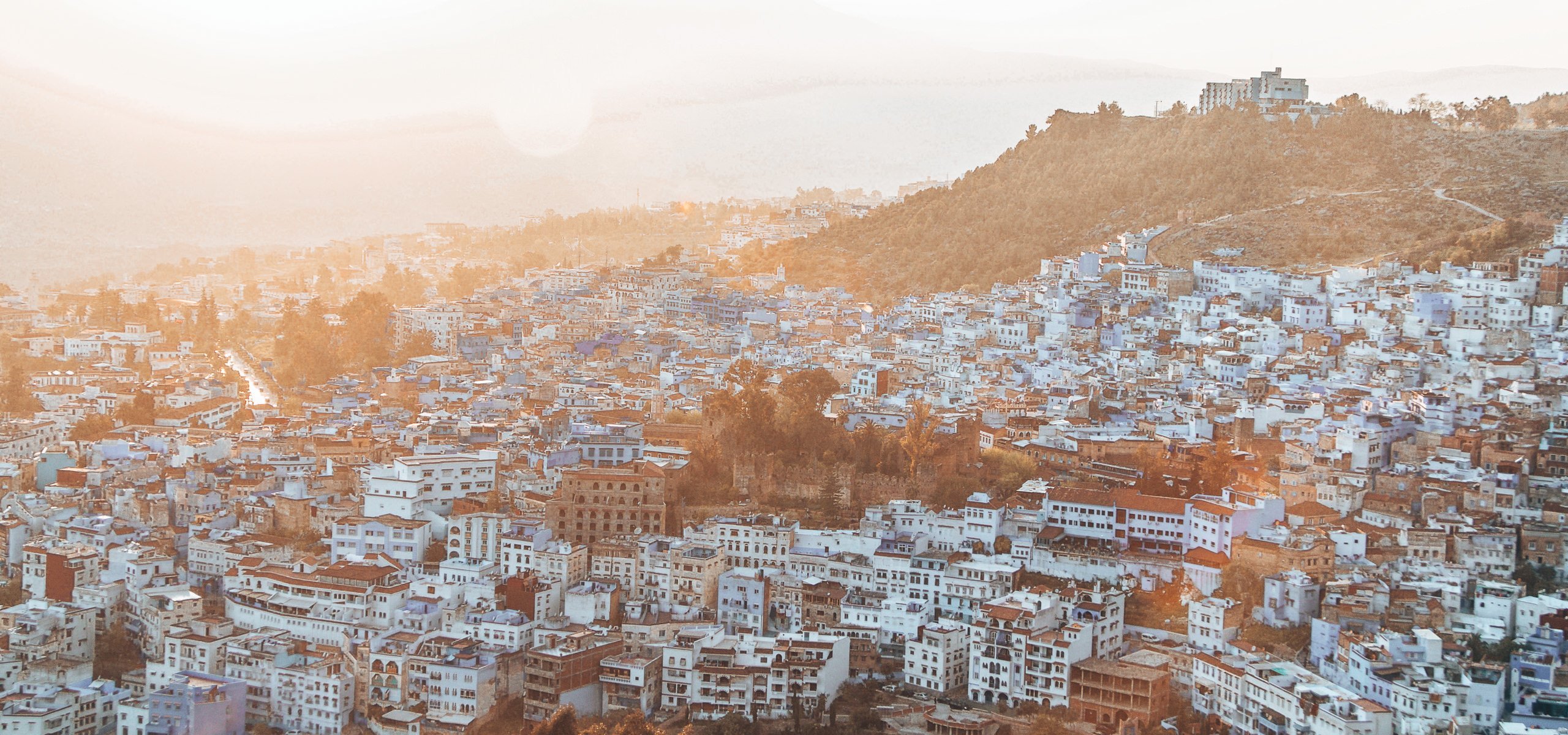 How many days in Chefchaouen | The sun sets over Chefchaouen, lighting up the blue city with a soft golden glow, Chefchaouen