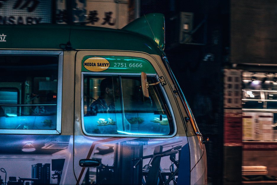 A driver of a public light bus in the shadows, Mong Kok, Hong Kong