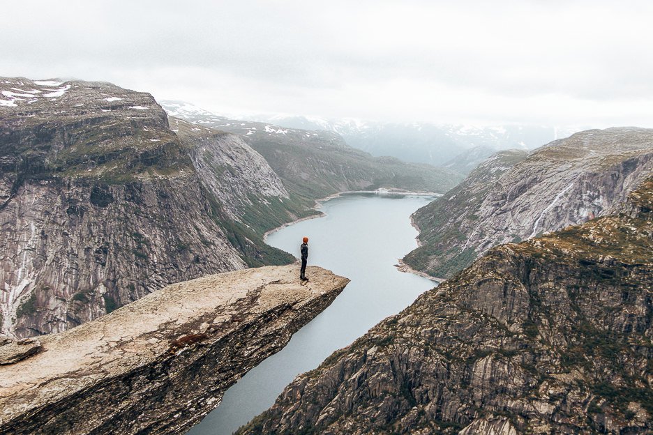 Jasmine stands on Trolltunga taking in the view over the fjord - Norway
