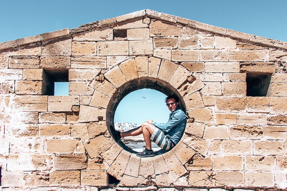Your Complete Travel Guide To Essaouira Morocco 7 L Bevan sitting in the wall at Scala du Port