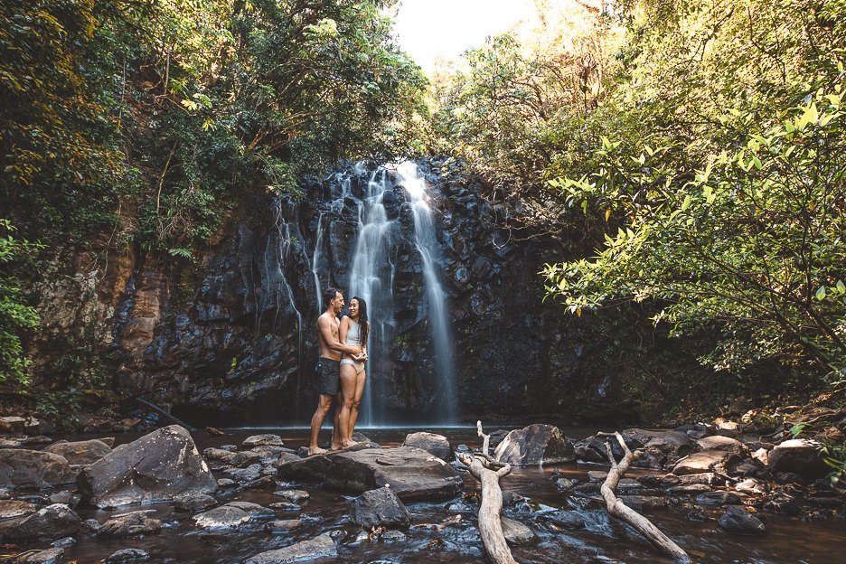 A couple share a cuddle underneath Ellinjaa Falls in tropical North Queensland