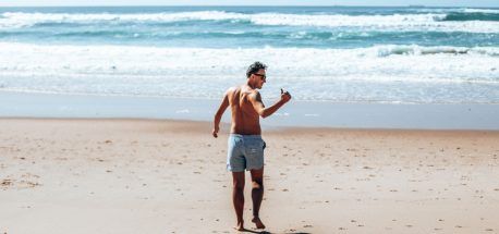 Bevan walks down to the beach wearing Eubi board shorts giving the thumbs up sign