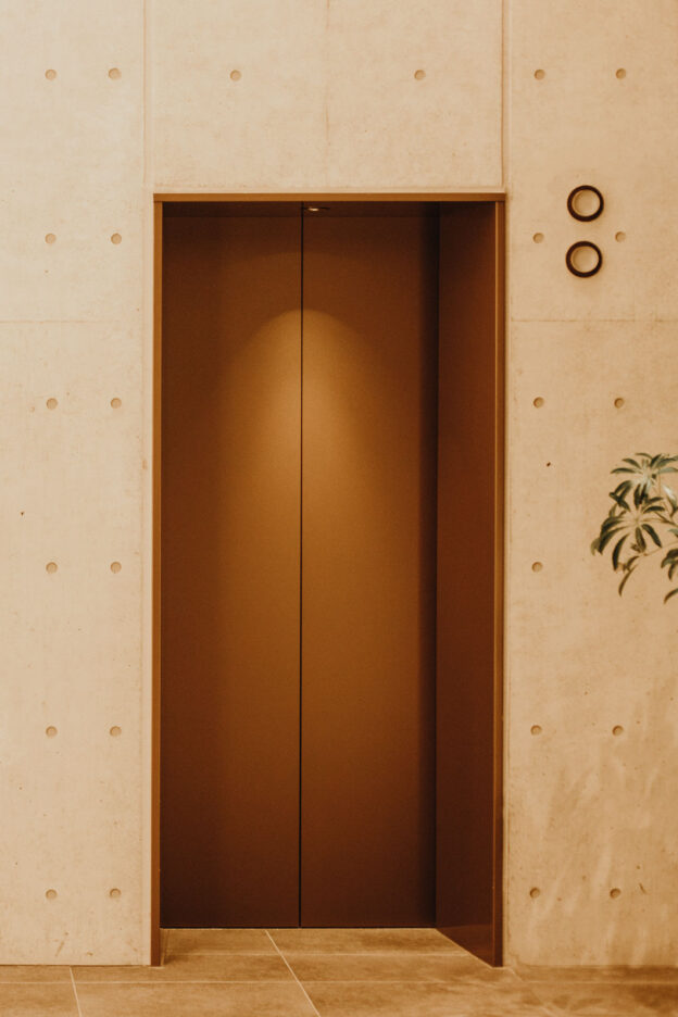 Elevator doors in the hotel lobby of The Lively Azabujuban, boutique hotel in Tokyo Japan