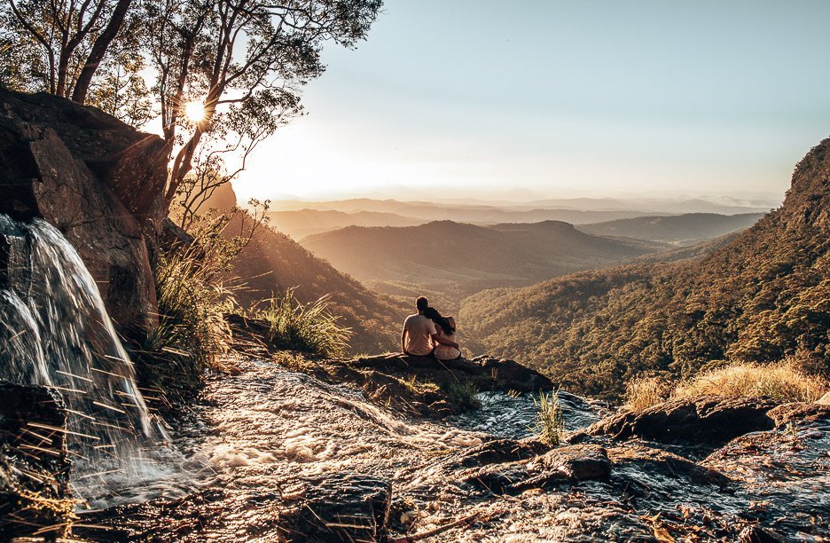 Couple watch the sunset at Moran Falls, Gold Coast, Queensland
