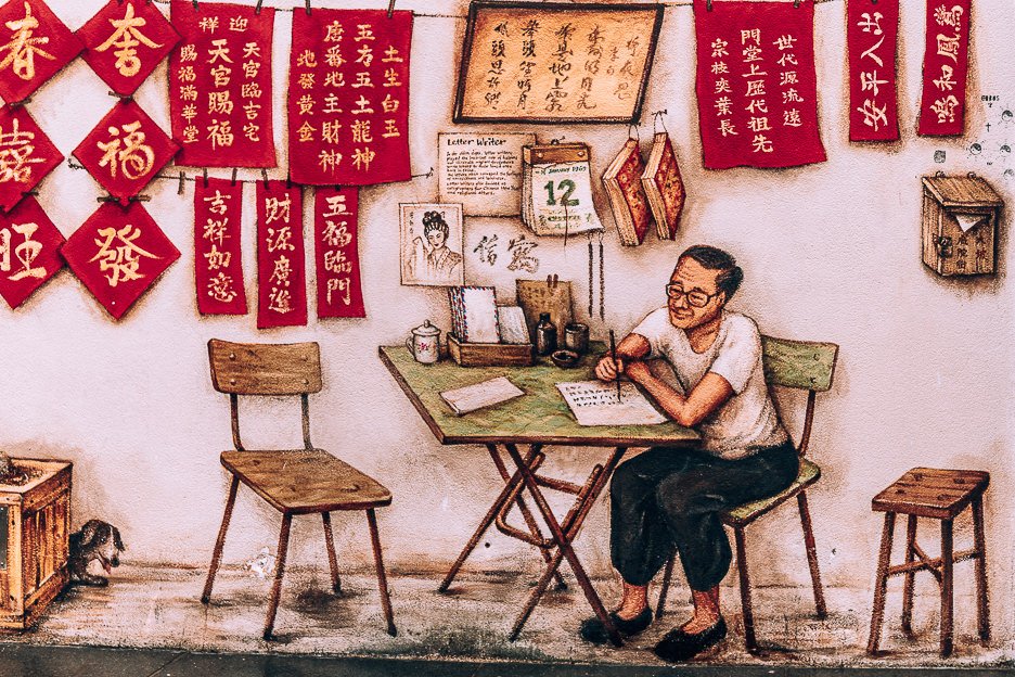 A mural of a man writing Chinese characters in Chinatown