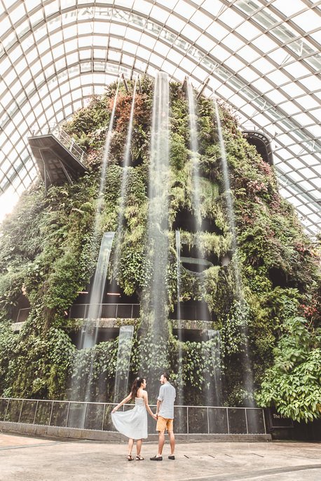 A couple stand underneath the largest indoor waterfall inside the Cloud Forest at Gardens By The Bay | 3 Day Singapore Itinerary