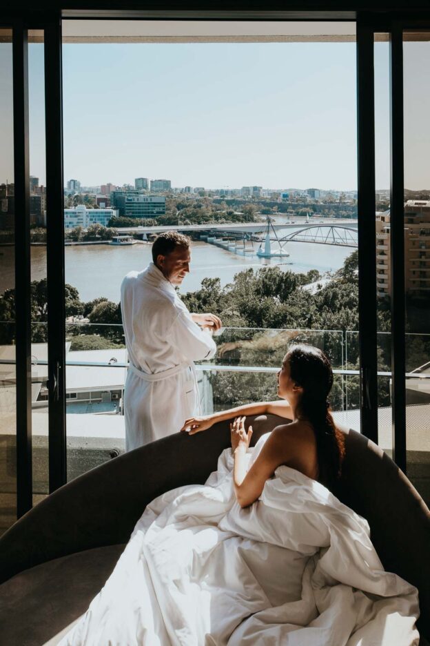 A couple bask in the morning sunshine whilst enjoying the view of the Brisbane River from the Emporium Hotel, South Bank, Brisbane