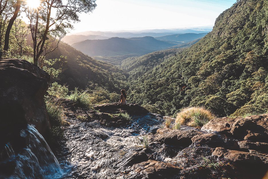 Gold Coast Airbnbs 1 L A girl sits on the edge of Moran Falls, Gold Coast Hinterland