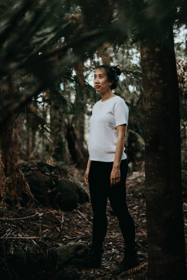 A girl poses for a photo amongst The Myrtle, a little rainforest near The Keep. Tasmania, Australia