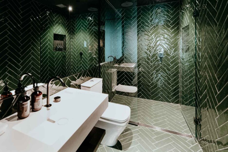 Deep green tiles inside bathroom of Grove Room 25 - MOSS Hotel, Hobart