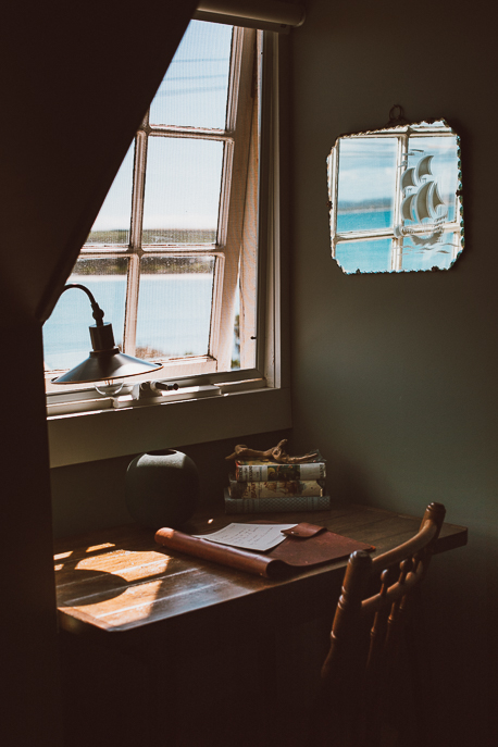 The wooden writing desk with vintage lamp underneath a window in the Greenhills Suite, The Ship Inn Stanley. Tasmania, Australia